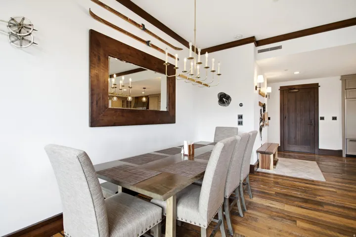 Hardwood flooring, wood-framed mirror, candelabra chandelier, wood ceiling beams, and wood door
