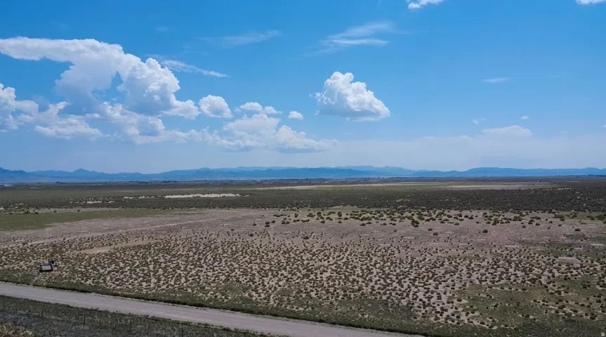 Expansive open terrain featuring natural vegetation and distant mountain ranges