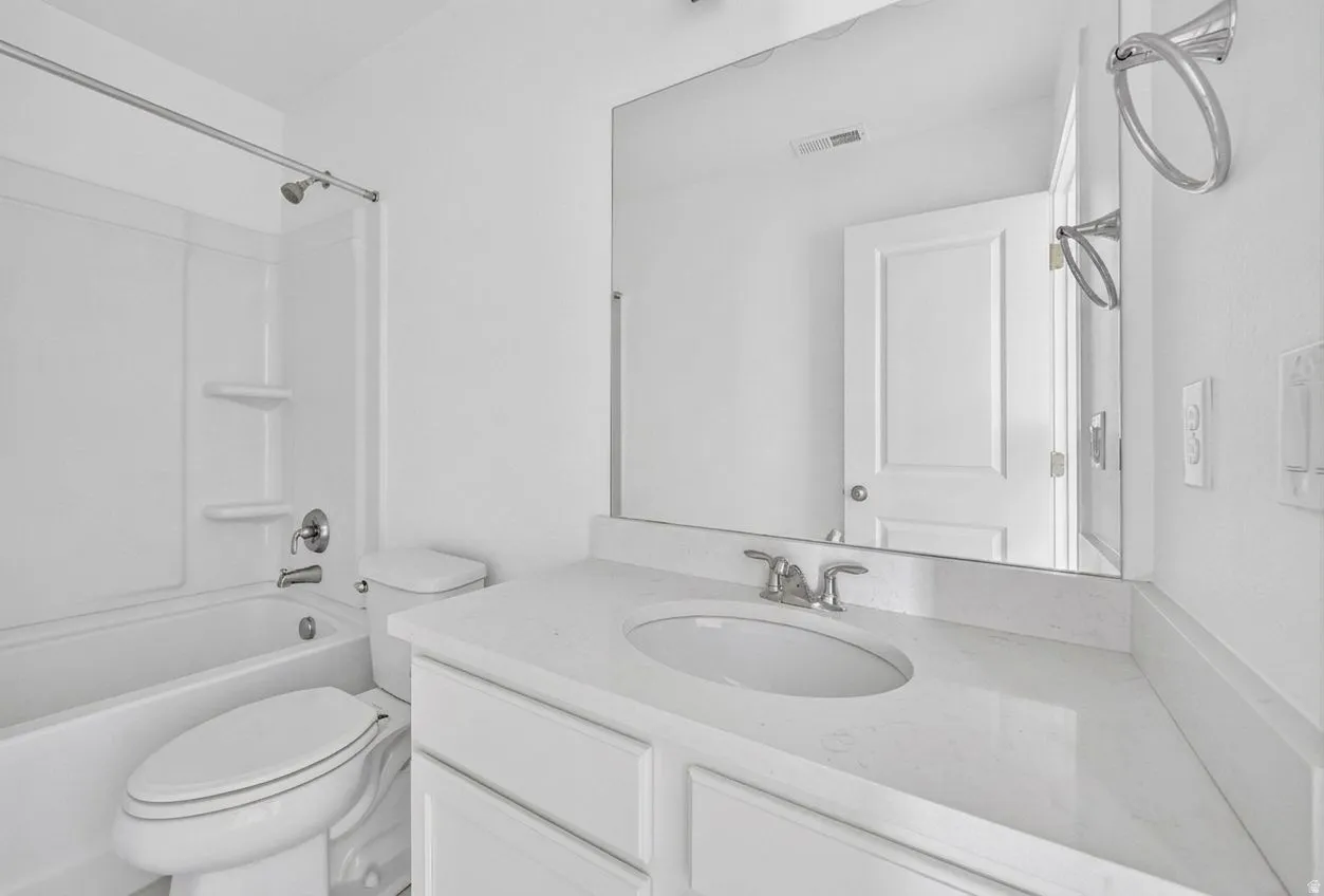 Vanity with an integrated sink, polished chrome faucet, and expansive mirror