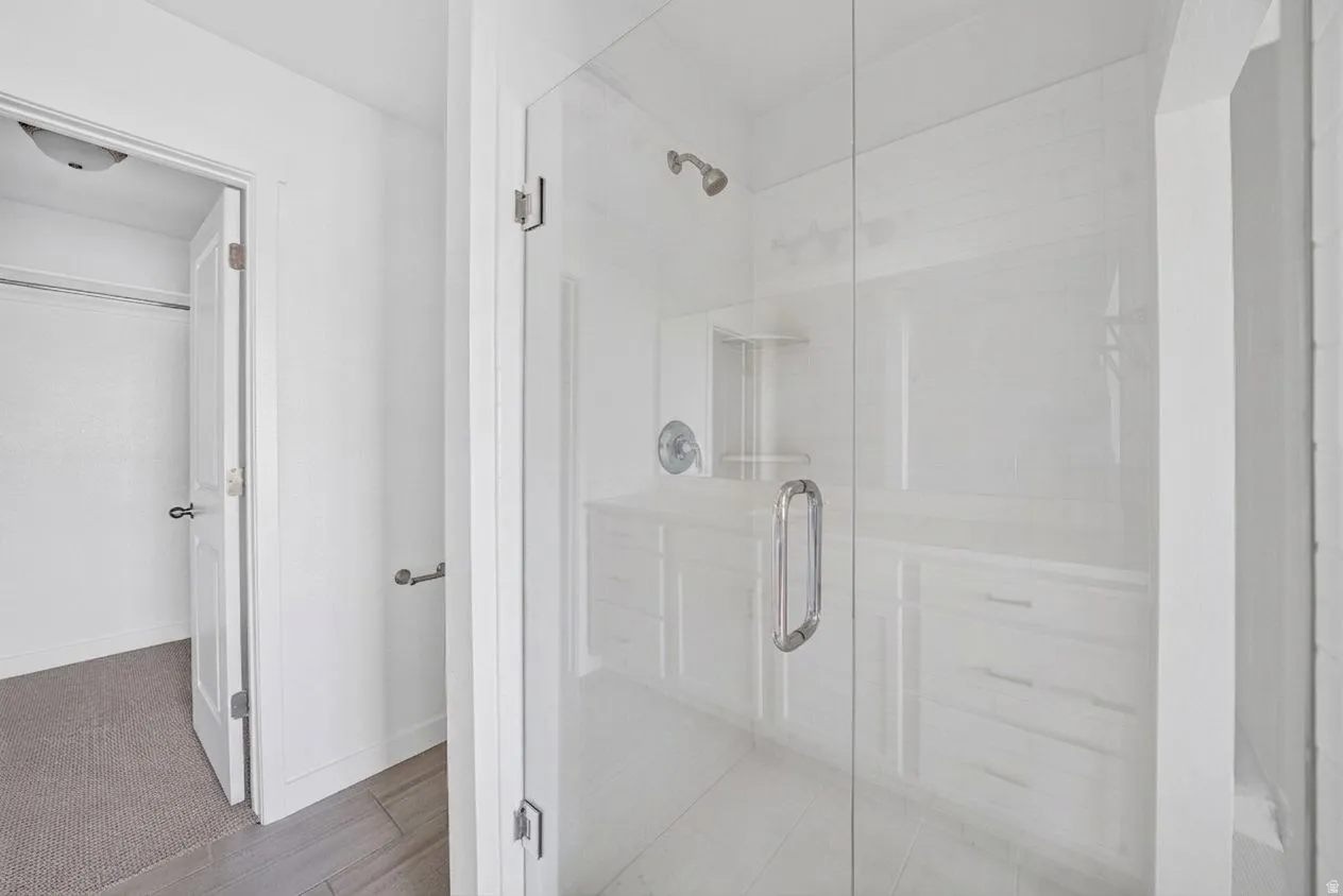 Glass-enclosed shower with a built-in niche, chrome fixtures, and a white subway tile surround
