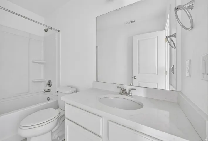 Vanity with an integrated sink, polished chrome faucet, and expansive mirror