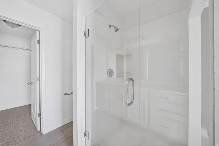 Glass-enclosed shower with a built-in niche, chrome fixtures, and a white subway tile surround
