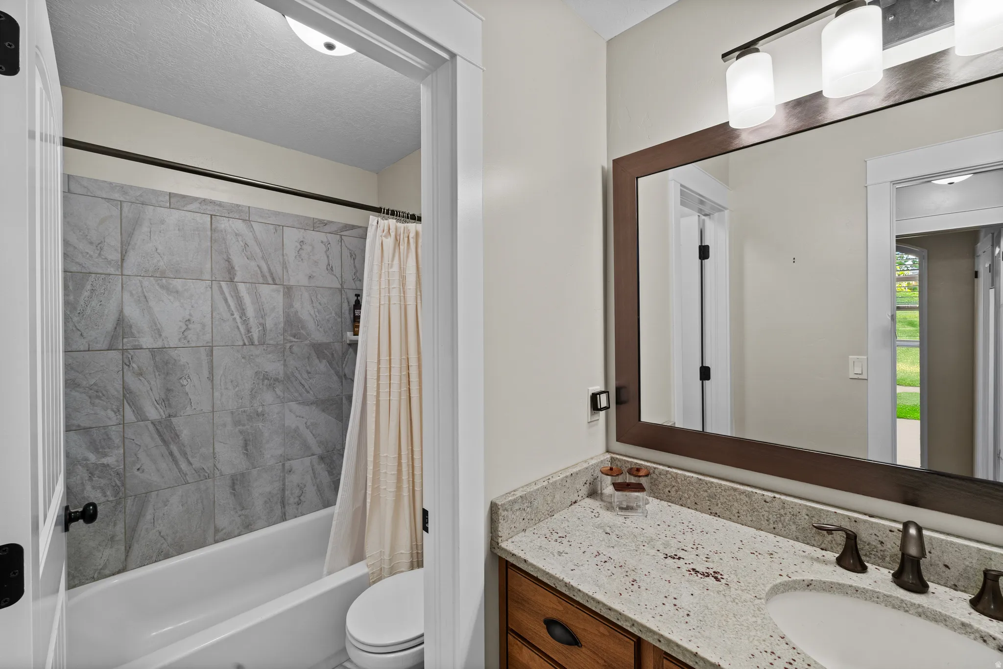 Vanity with a light-toned countertop, undermount sink, and dark-toned faucet