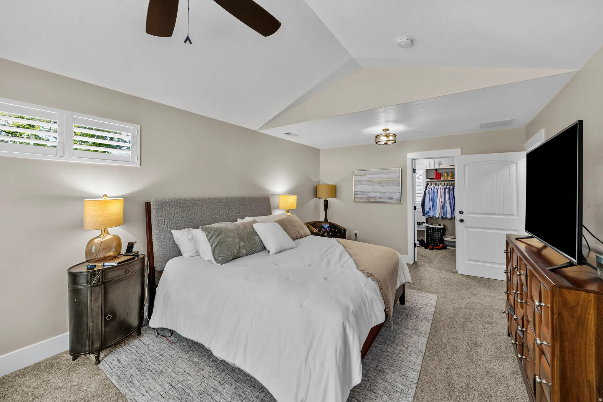 Tray ceiling accentuates the bedroom with carpet flooring