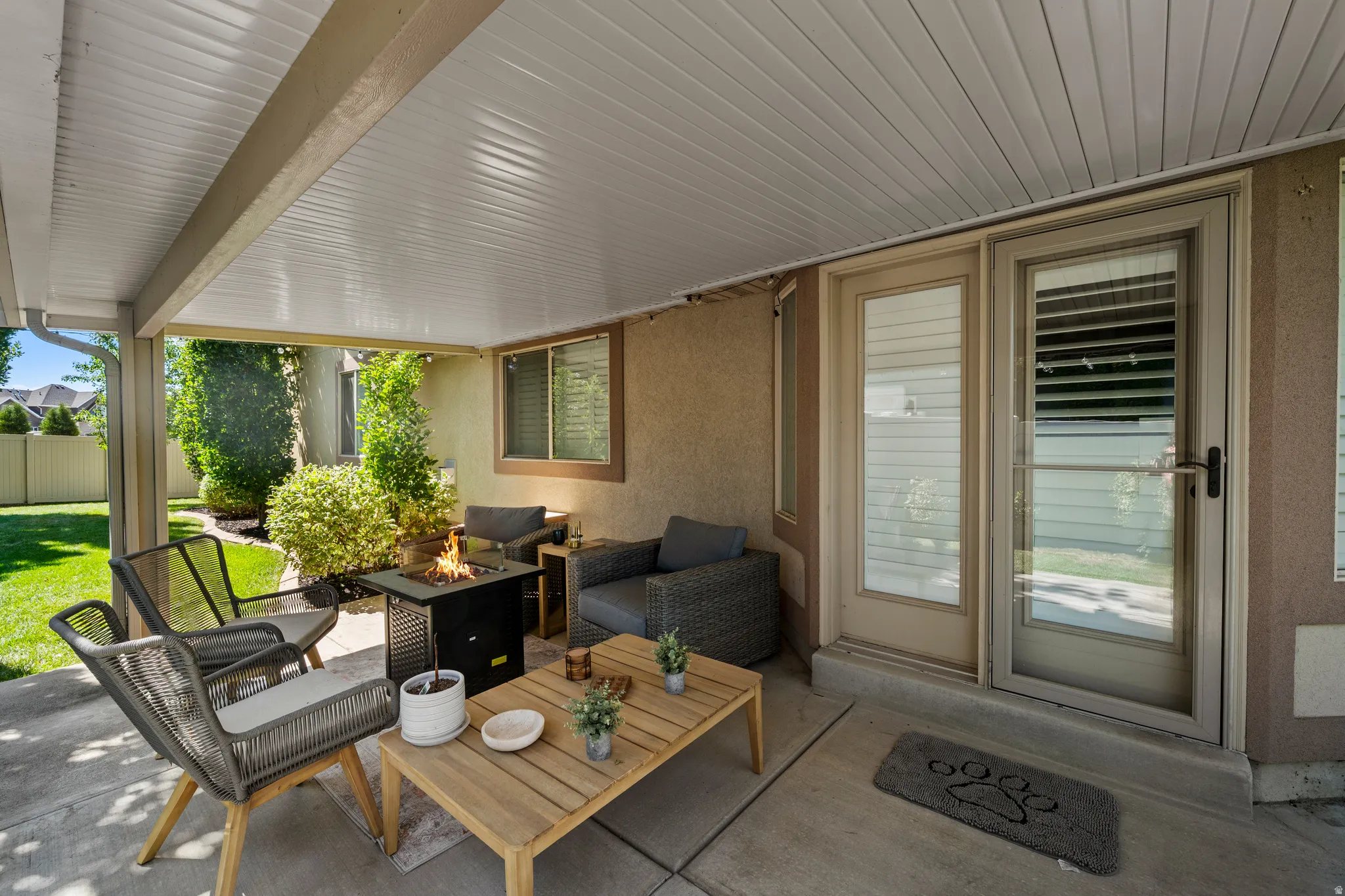 Covered patio with concrete flooring, stucco exterior, and a sliding glass door