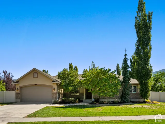 Warm-toned stucco and brick exterior with a prominent two-car garage