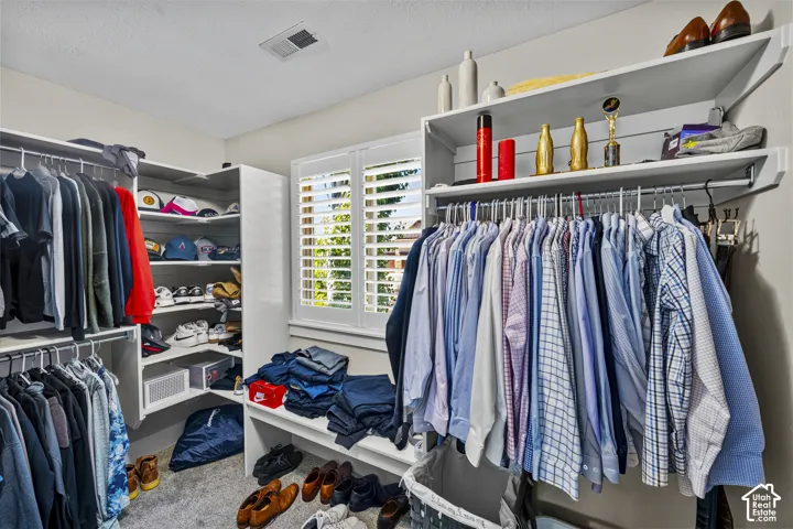 Custom closet system with white shelving, multiple hanging rods, and built-in storage