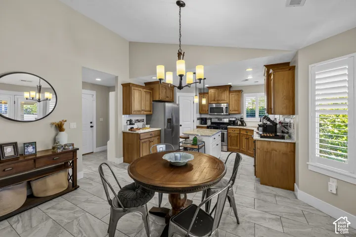 Vaulted ceiling, tile flooring, wood cabinetry, stainless steel appliances, and white plantation shutters