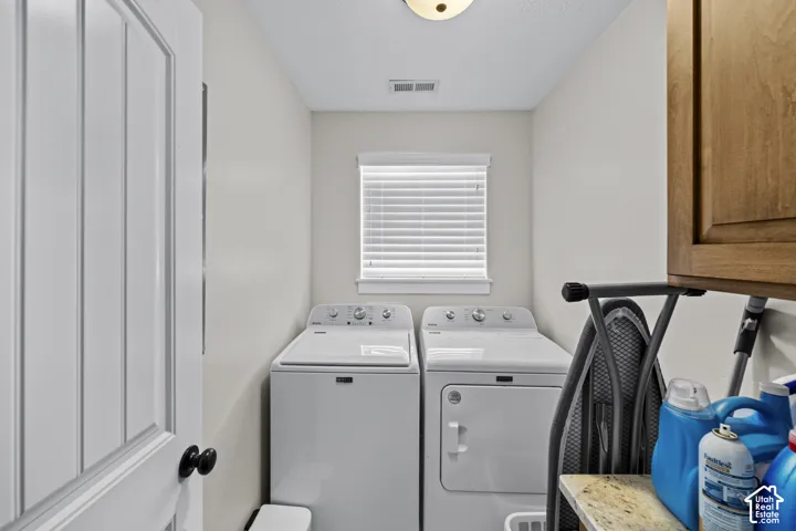 Dedicated laundry space featuring a window, built-in cabinetry, and a countertop