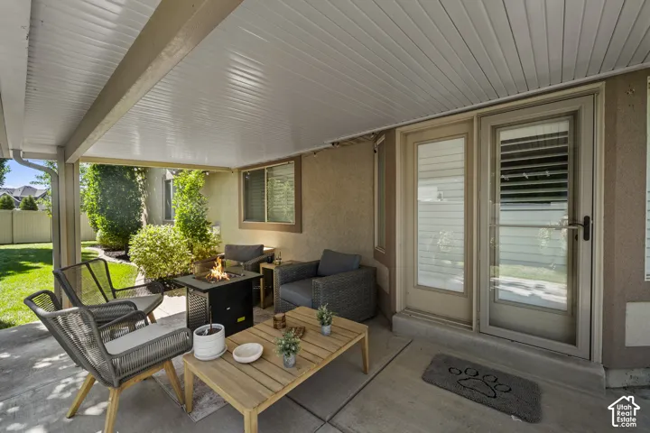 Covered patio with concrete flooring, stucco exterior, and a sliding glass door