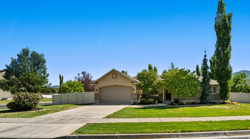 Warm-toned stucco and brick exterior with a prominent two-car garage
