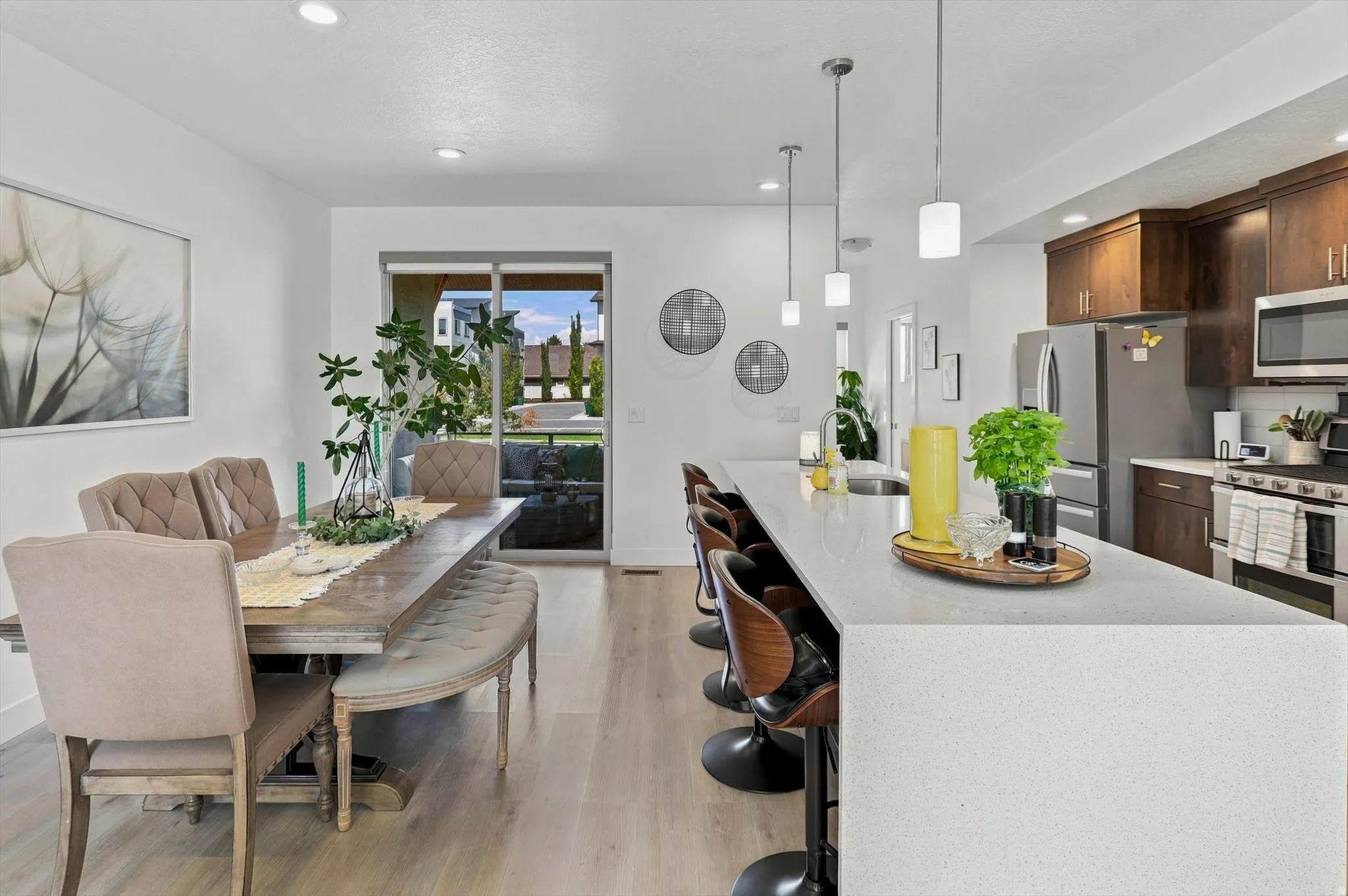 Open concept living area with wood-finish flooring, recessed lighting, and a sliding glass door