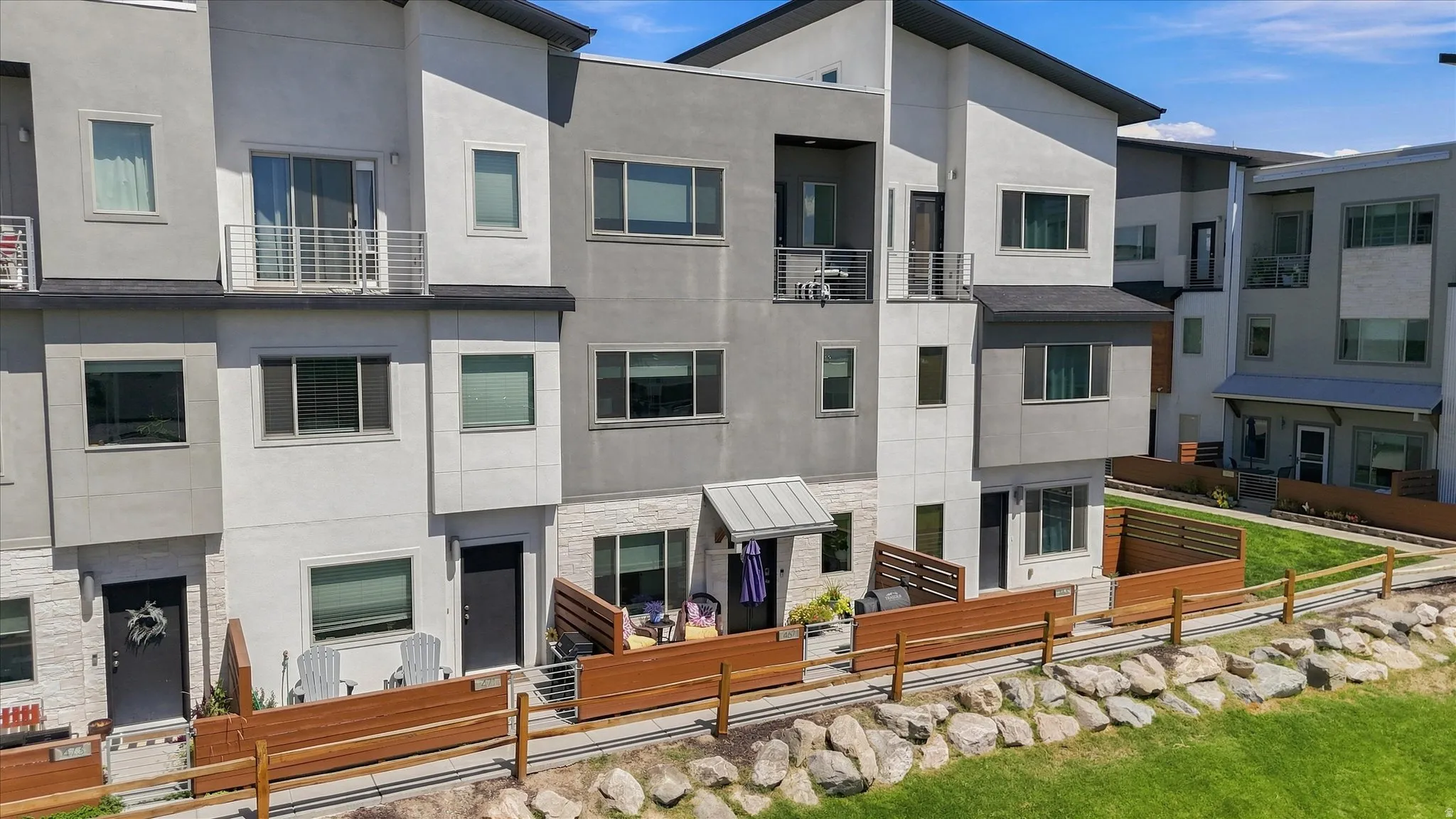 Multi-level façade with contrasting grey and white stucco
