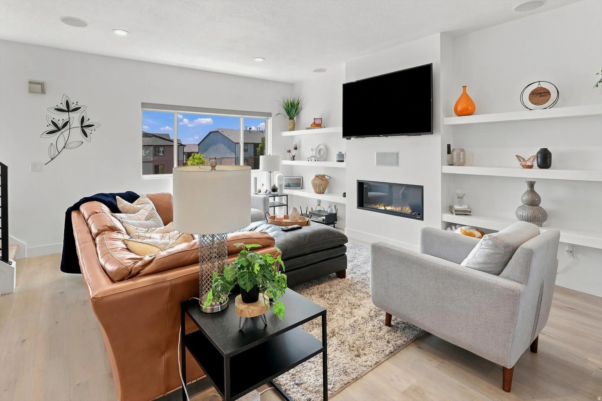 Open-concept living space with light-tone wood-finish flooring