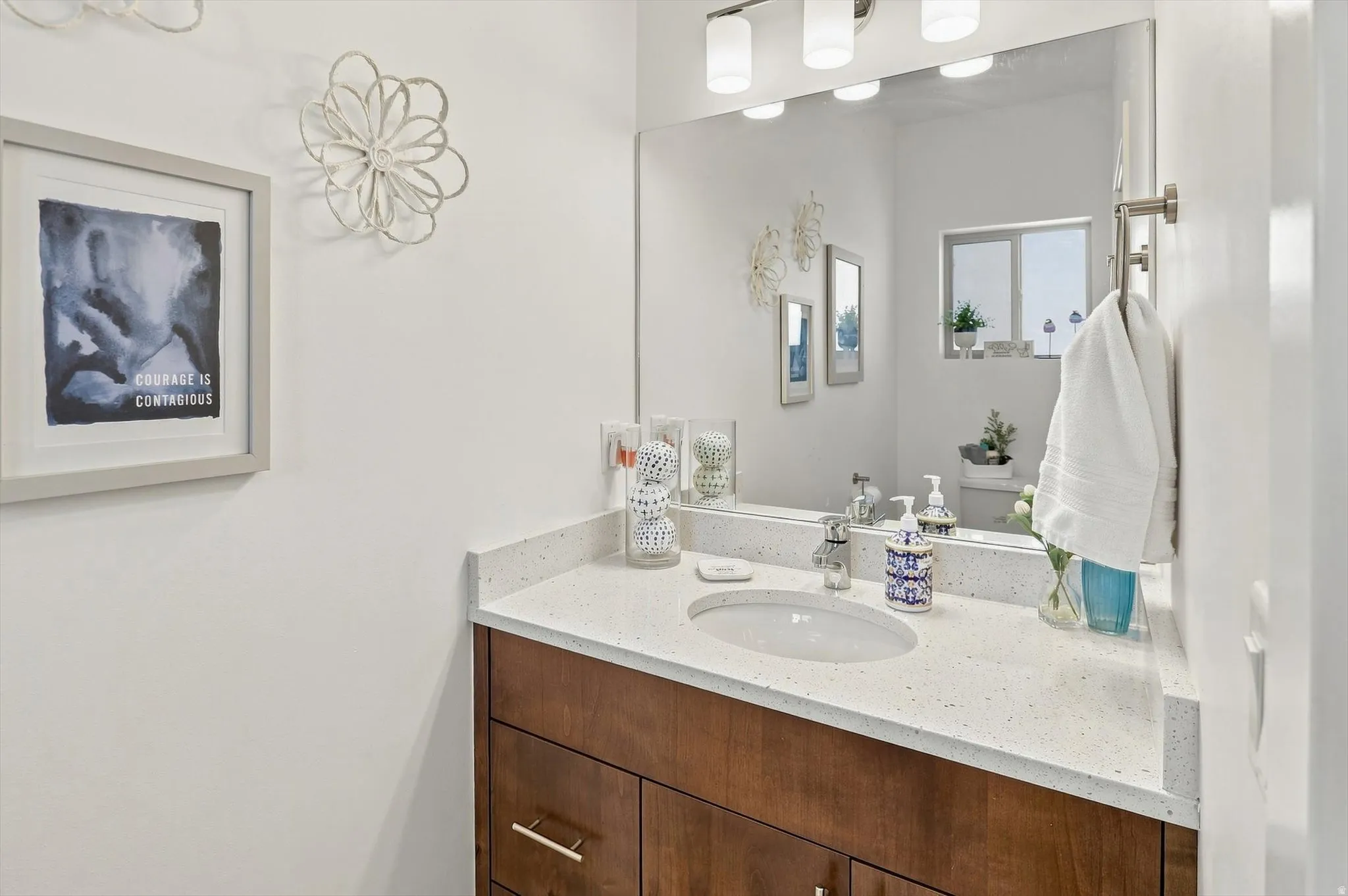 Wood-finish vanity with an integrated sink and light-colored countertop