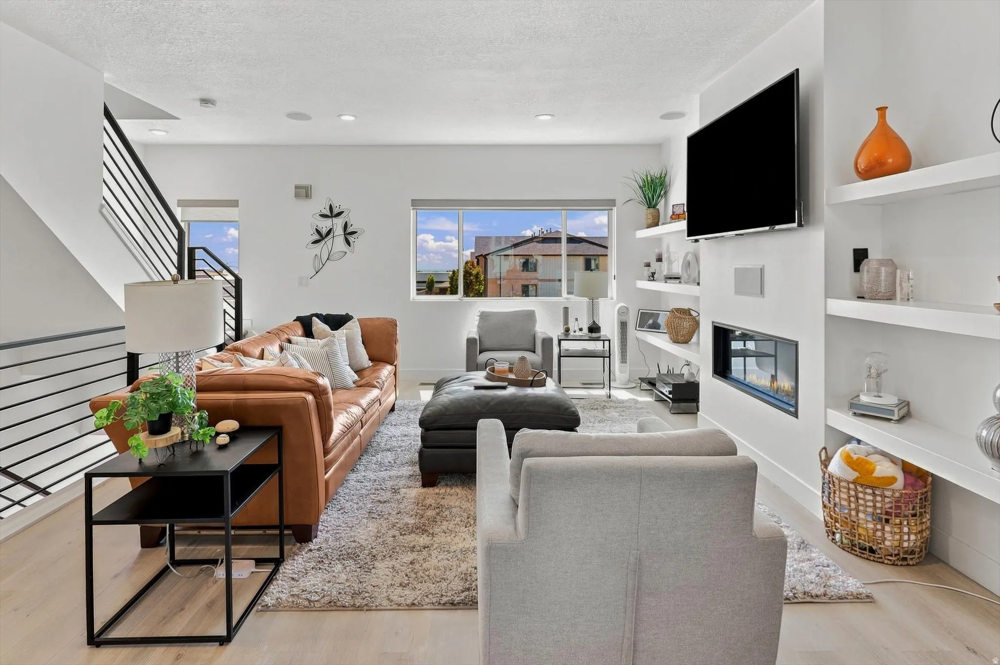 Open-concept living space with light wood-finish flooring
