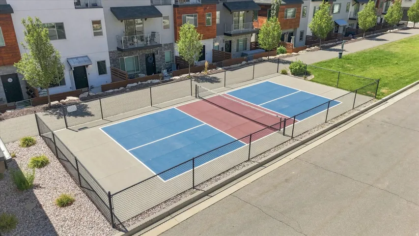 Fenced outdoor court with blue and red playing surfaces