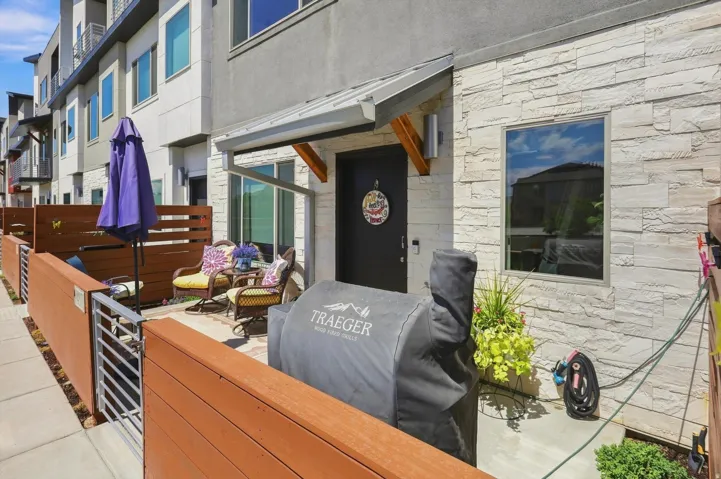 Private patio featuring composite fencing and a metal gate