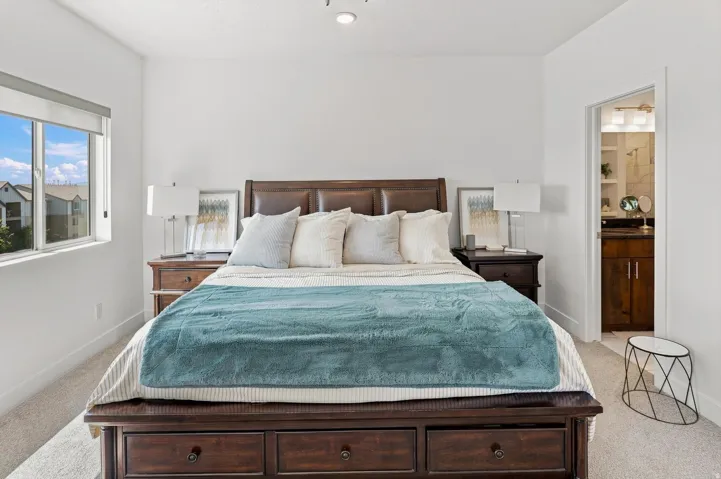 Recessed ceiling lighting, a window with roller shade, and light-colored carpet flooring