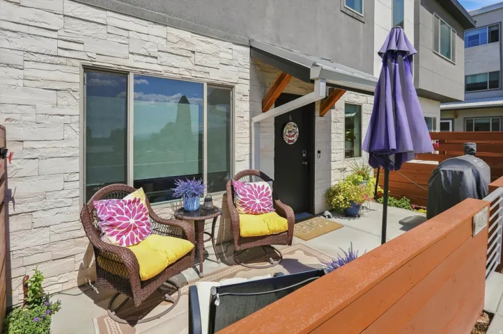Patio with concrete flooring, stone veneer exterior, and wood fencing
