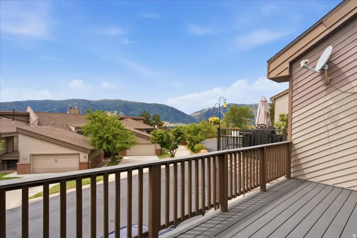 Deck with composite decking and wood railing, offering a mountain backdrop and neighborhood setting