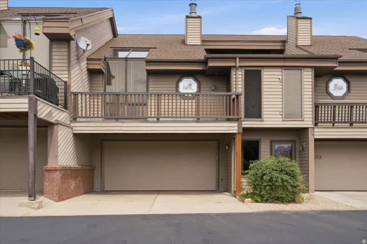 Multi-level exterior with horizontal siding, a private balcony, and an attached two-car garage