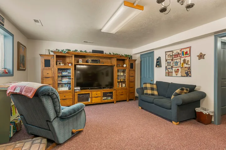 Built-in entertainment center with integrated shelving, light-colored walls, and a window with trim
