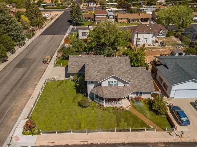 Two-story residence with a covered front porch, a two-car garage, and a manicured front lawn enclosed by a white picket fence