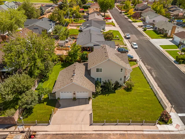 Two-story residence featuring a detached two-car garage, concrete driveway, and expansive front lawn