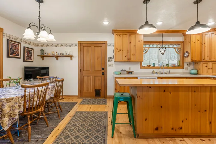 Wood-finish flooring throughout, with a dining area featuring a chandelier