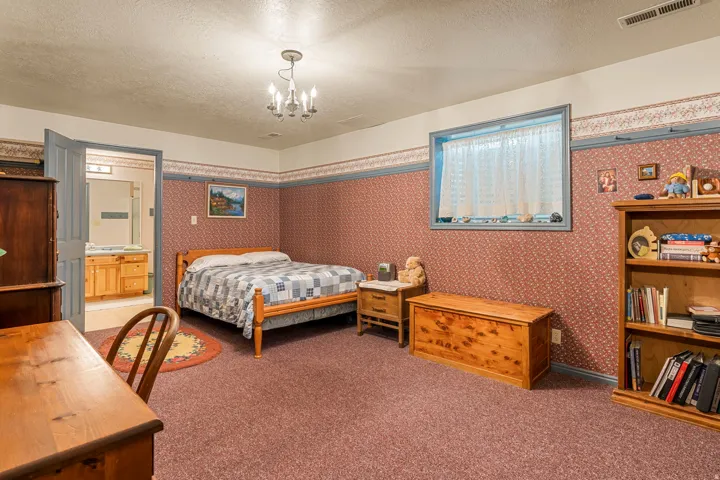 Carpeted flooring with an overhead chandelier