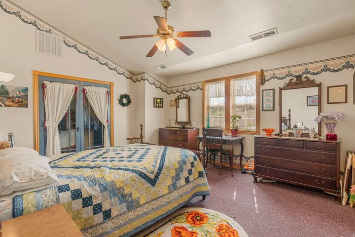 Ceiling fan with light fixture, window with wood trim, glass-paneled double doors with wood trim, textured ceiling, and recessed lighting