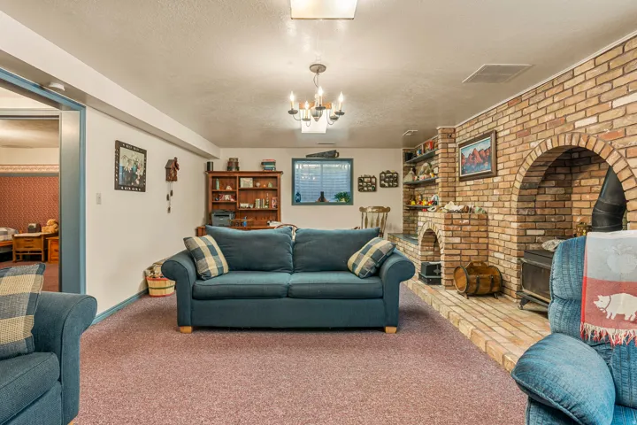 Brick-clad fireplace with arched opening, built-in shelving, and carpeted flooring