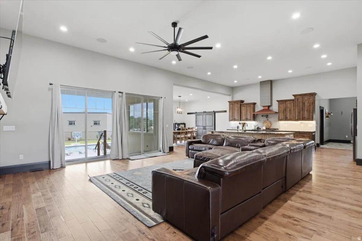 Open-concept living area featuring wood-finish flooring, recessed lighting, and a modern ceiling fan