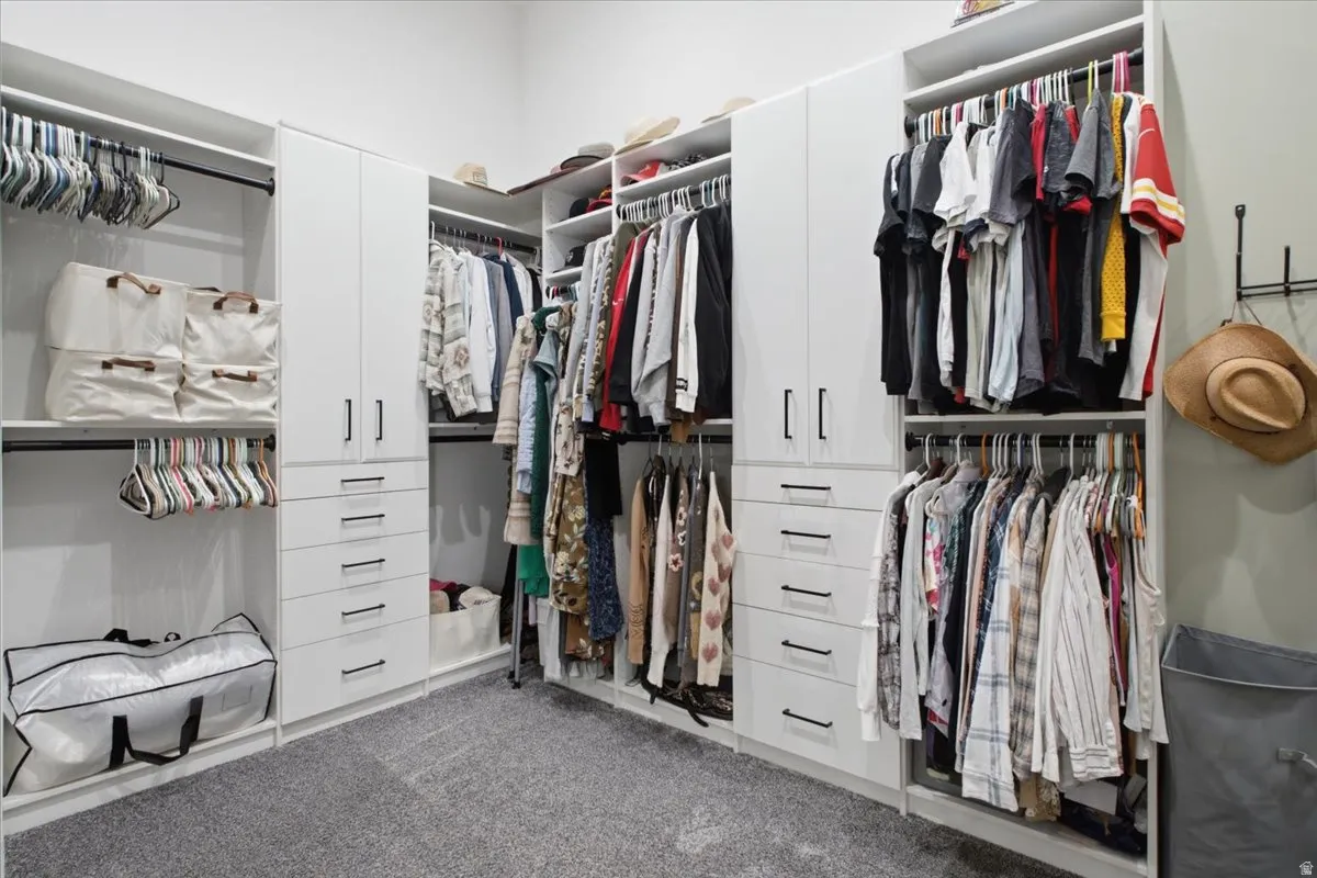 Custom closet system featuring multiple hanging rods, built-in shelving, and drawers, all within a light-toned interior