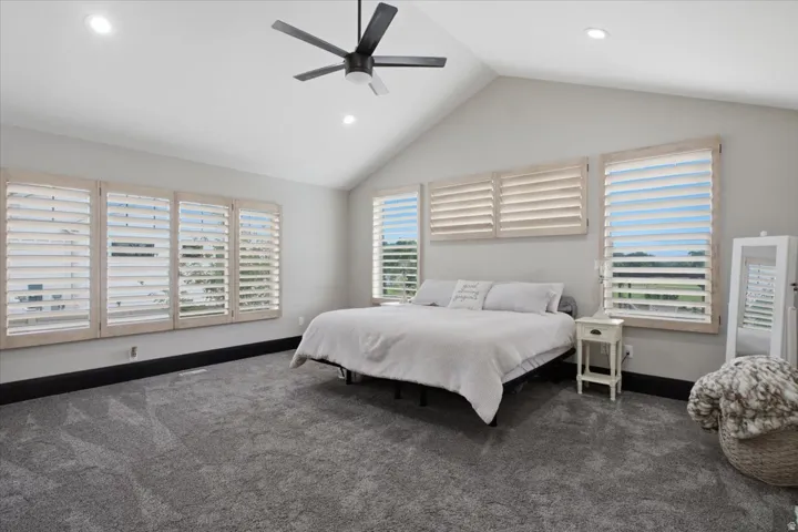 Vaulted ceiling with recessed lighting and a ceiling fan