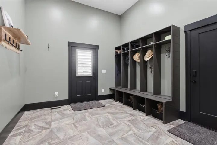 Built-in storage lockers, patterned floor tile, dark trim, and a door with louvered glass