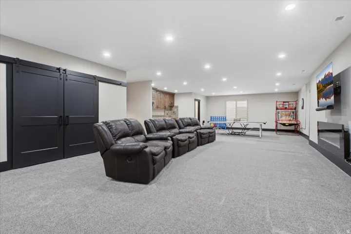 Spacious carpeted room featuring recessed lighting and a built-in electric fireplace