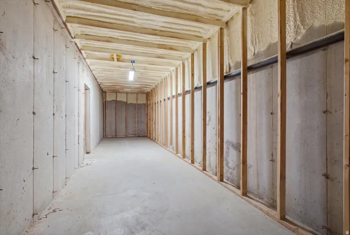 Unfinished basement with concrete flooring and exposed wood framing