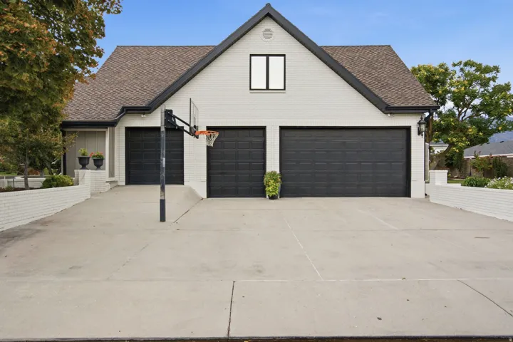 Brick exterior with dark trim and a brown shingle roof