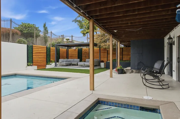Expansive concrete patio with a built-in pool and integrated spa