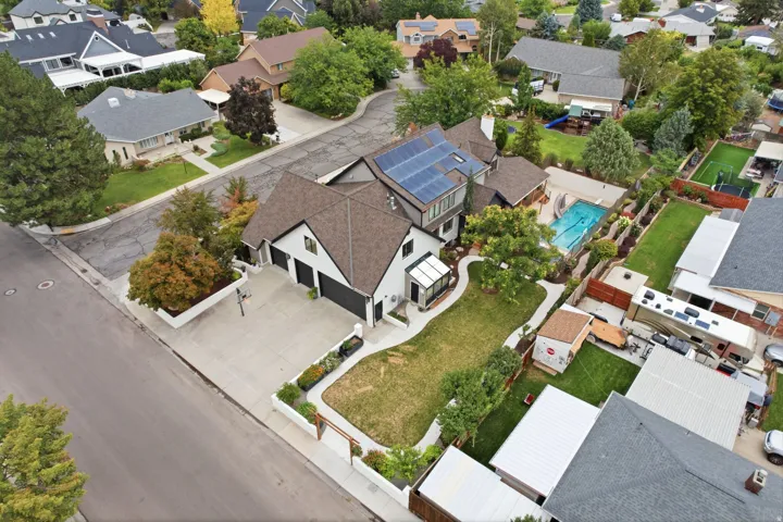 Modern residence featuring solar panels, a private swimming pool, two-car garage, and a manicured lawn
