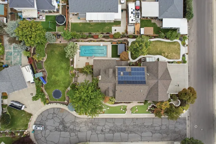Pitched roof with solar panel array, swimming pool, extensive lawn, mature trees, and cul-de-sac frontage