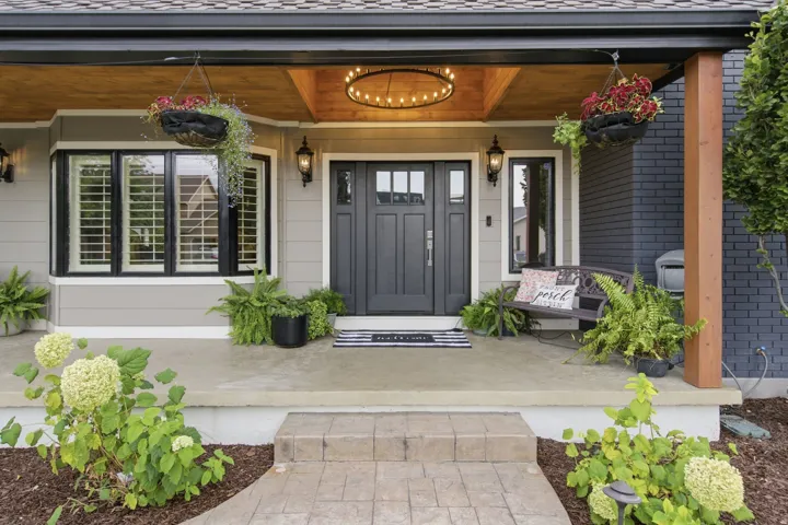 Covered front porch with wood-paneled ceiling and an architectural chandelier