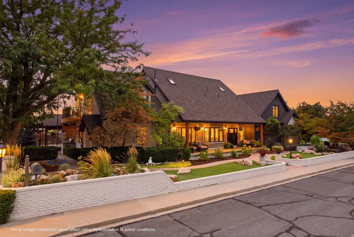 Spacious exterior with extensive landscaping, a covered front porch, a multi-tiered roofline, prominent gables, and a brick retaining wall
