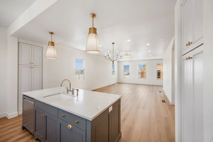 Kitchen island with integrated sink, stainless steel dishwasher, and white countertop