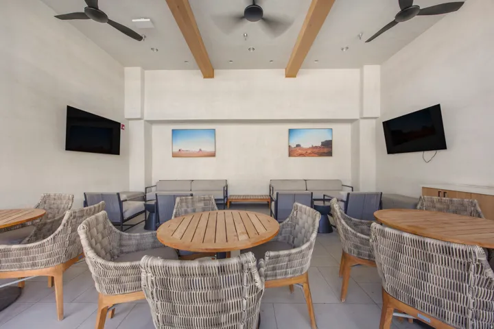 Recessed lighting, exposed wood ceiling beams, three ceiling fans, and built-in flat-screen televisions