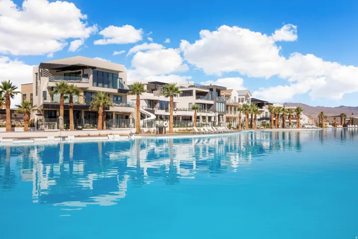 Expansive artificial lagoon with a surrounding hardscape and desert landscaping