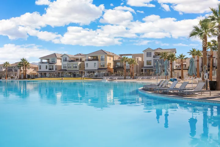 Expansive water feature with a curvilinear edge, surrounded by lounge seating and palm trees