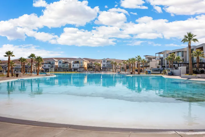 Expansive artificial lagoon with surrounding structures, integrated palm trees, and clear water